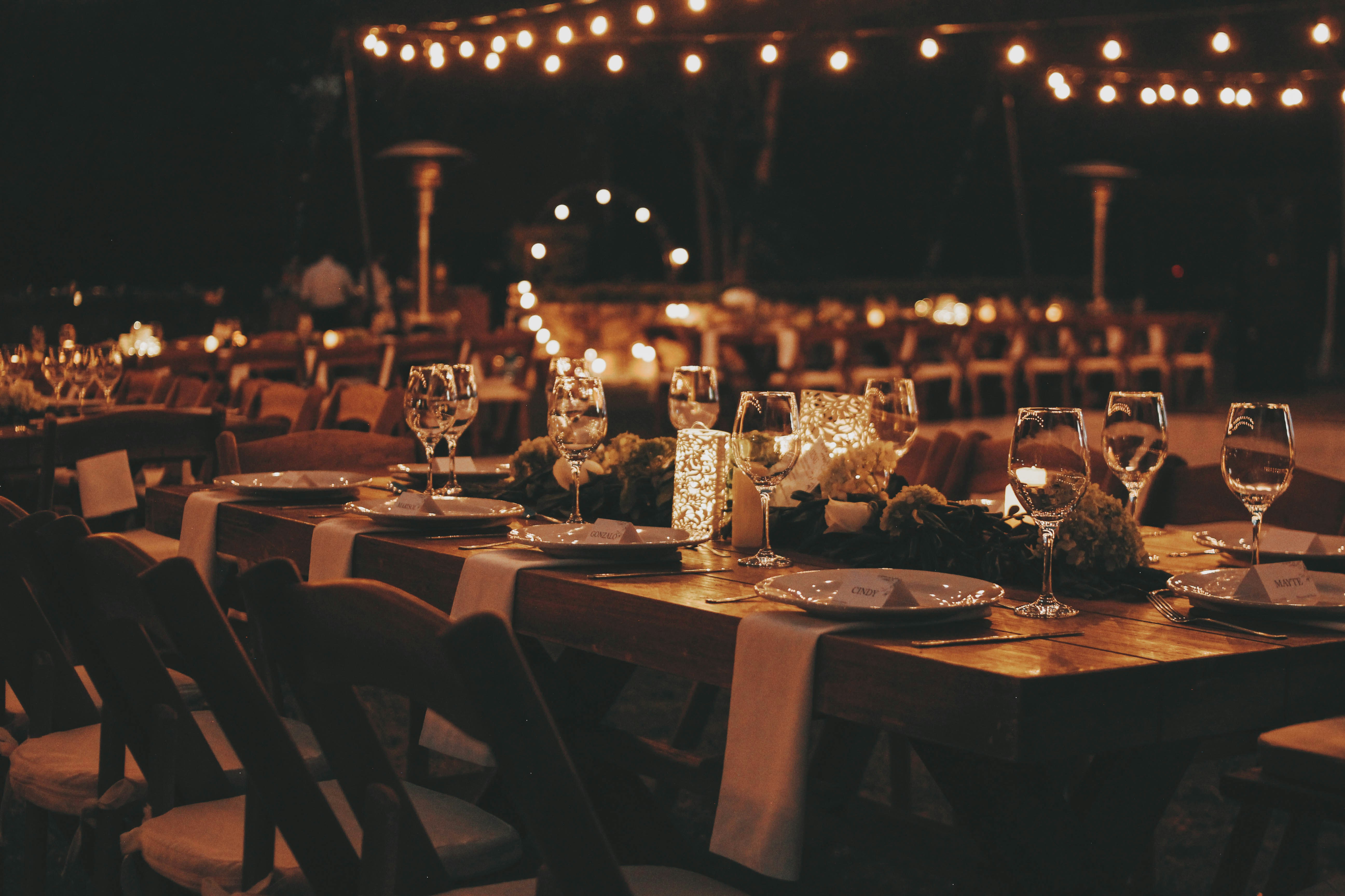 Open-air dining space with patterned draping, chandeliers, and buffet styling
