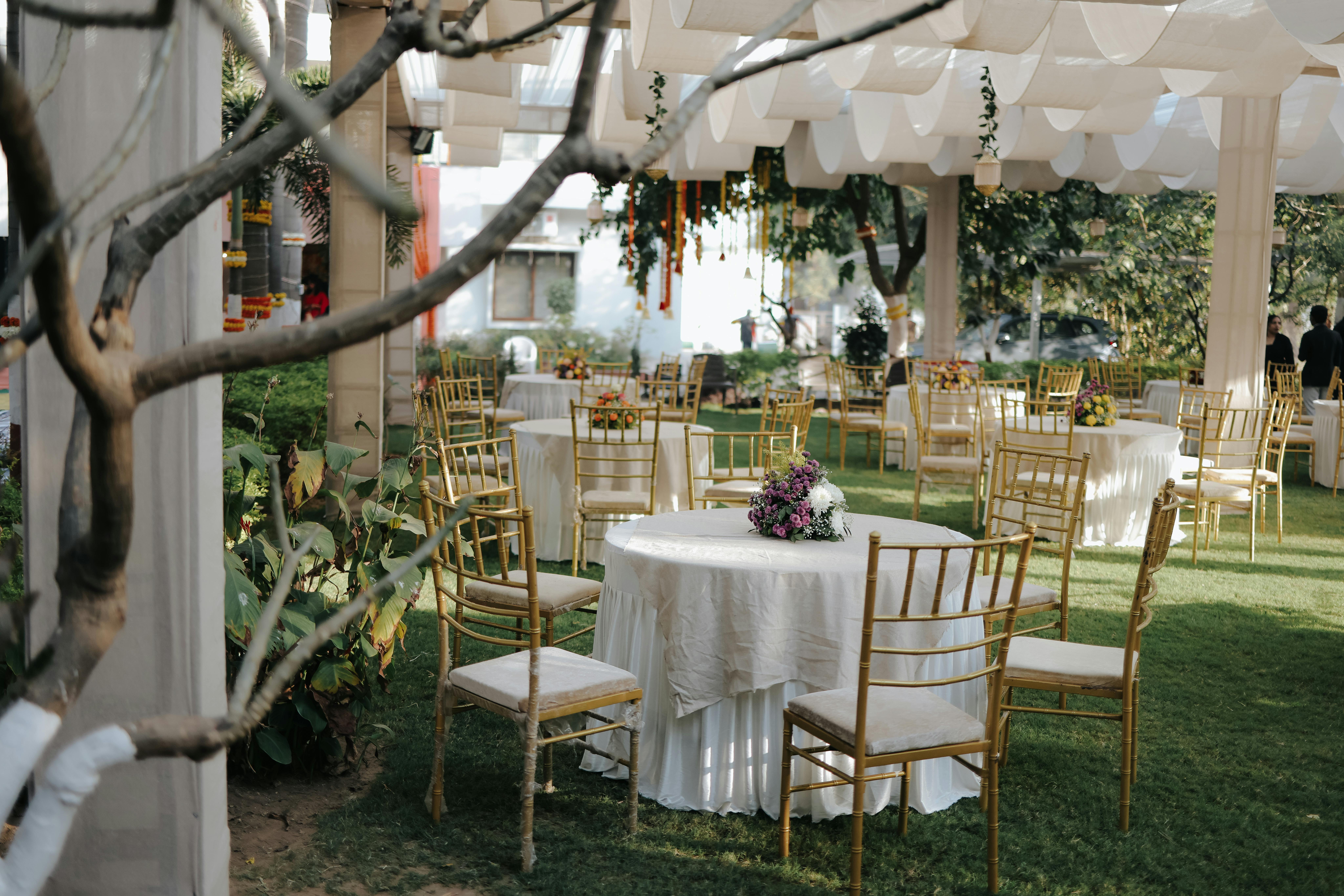 Garden reception with hanging candles, floral tablescape, and a long banquet table