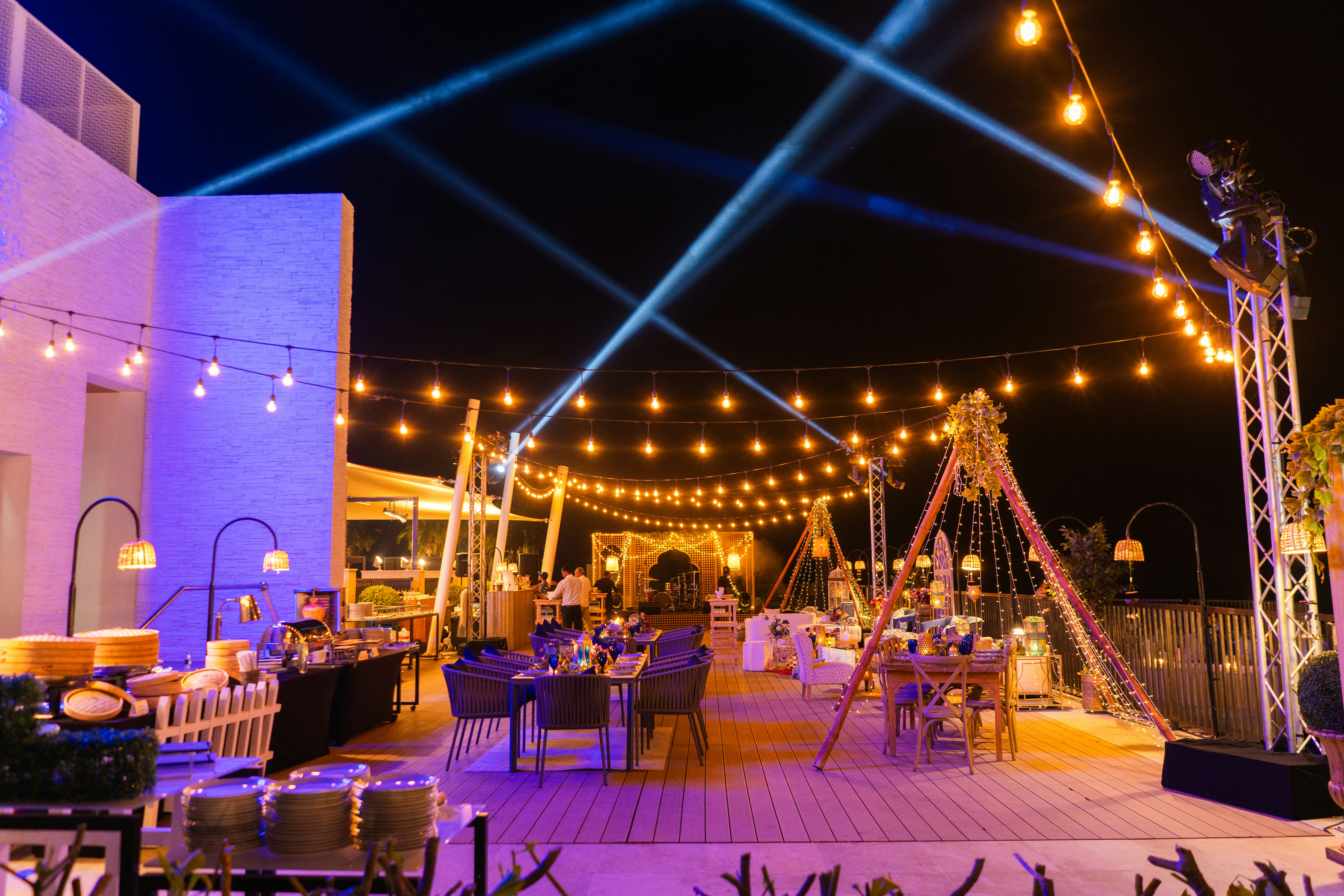 Elegant tent reception with round tables and wooden cross-back chairs
