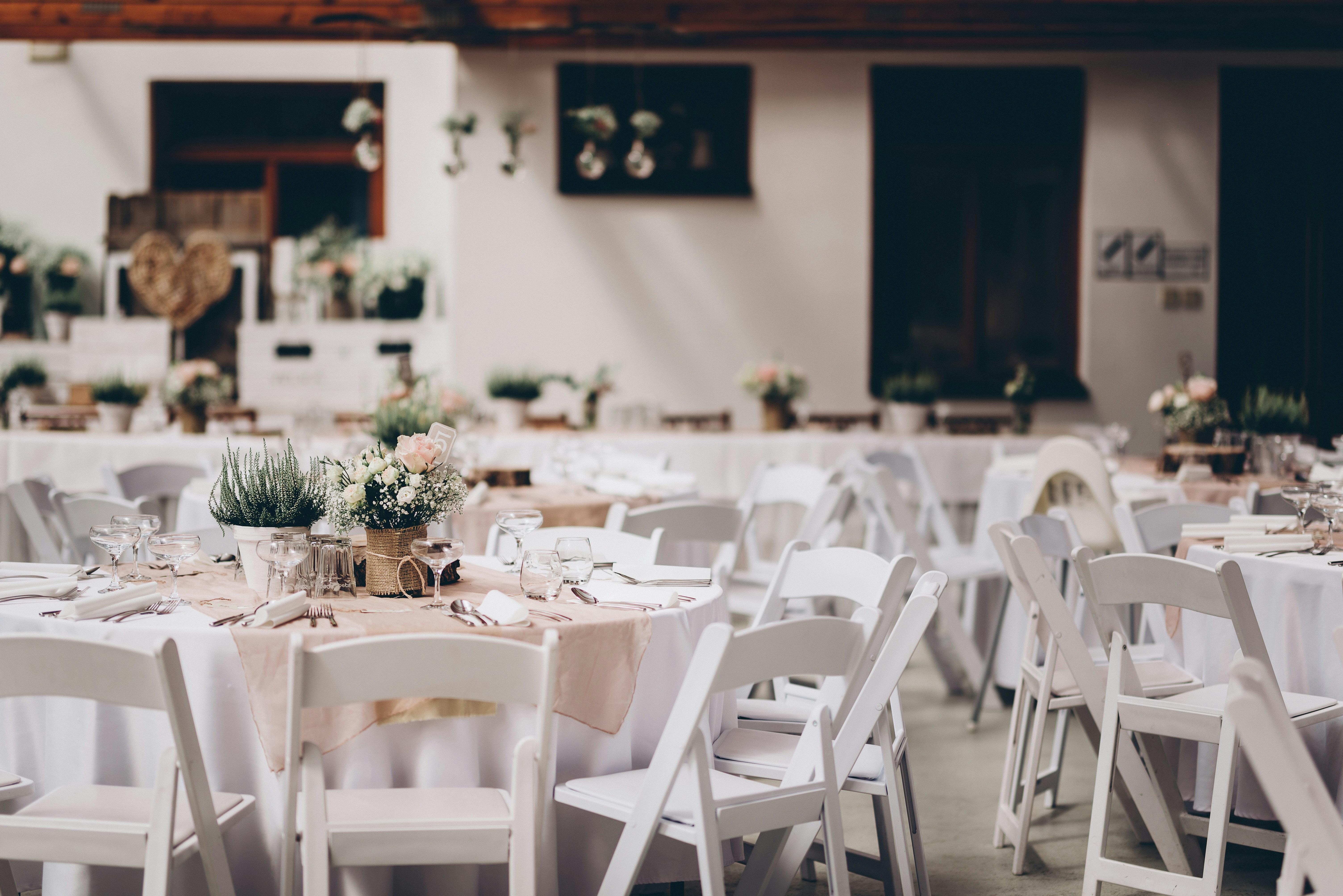 Outdoor venue with lavender-draped chairs and tall floral centerpieces