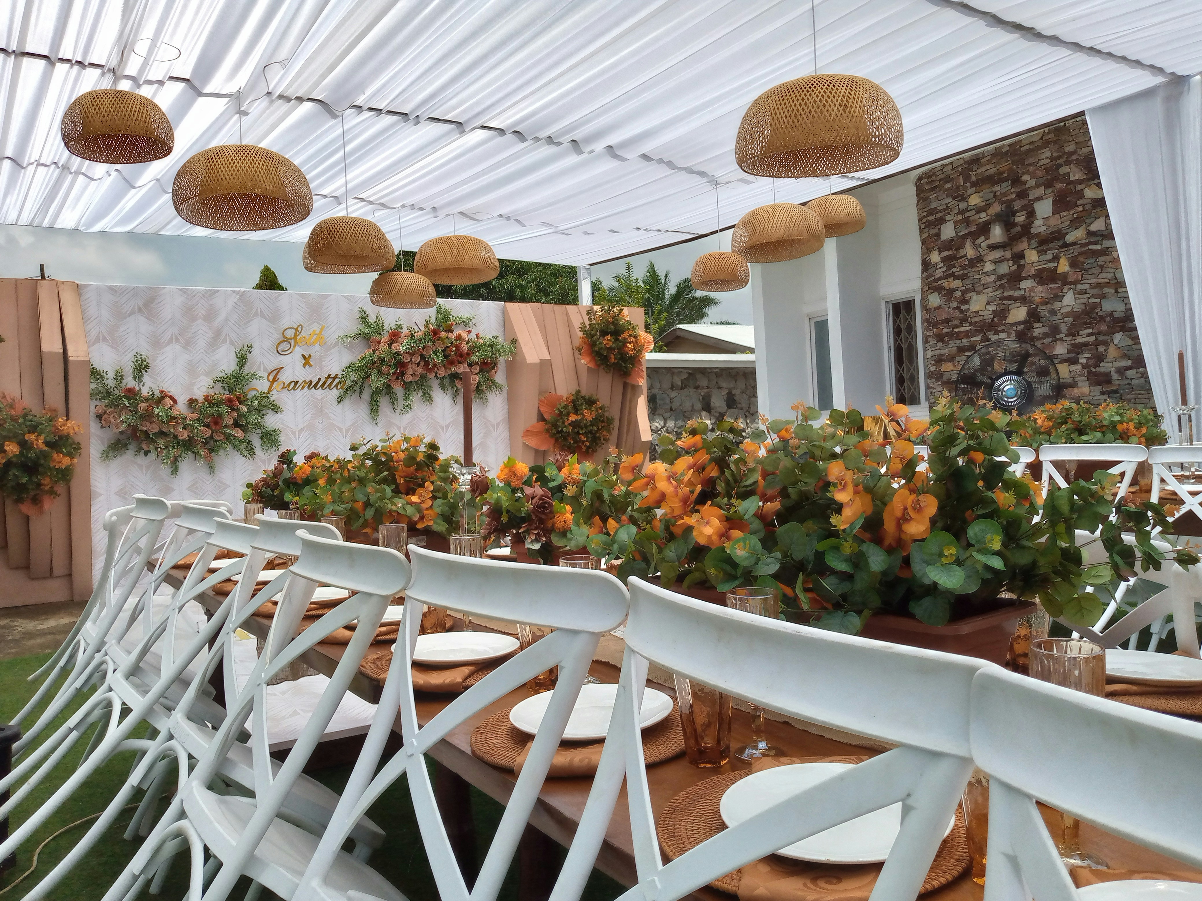 Rustic bamboo event hall with colorful ribbons and floral table styling