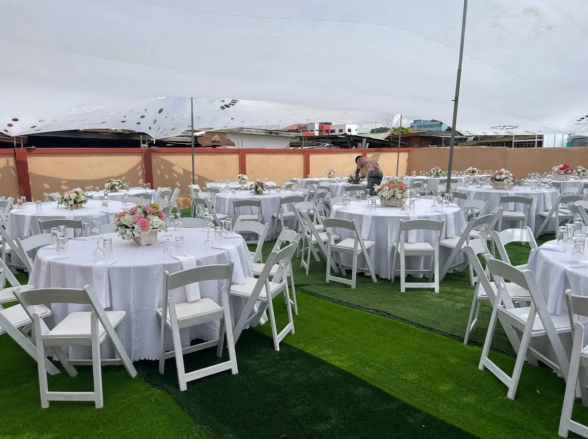 Outdoor reception setup with white table styling and floral centerpieces